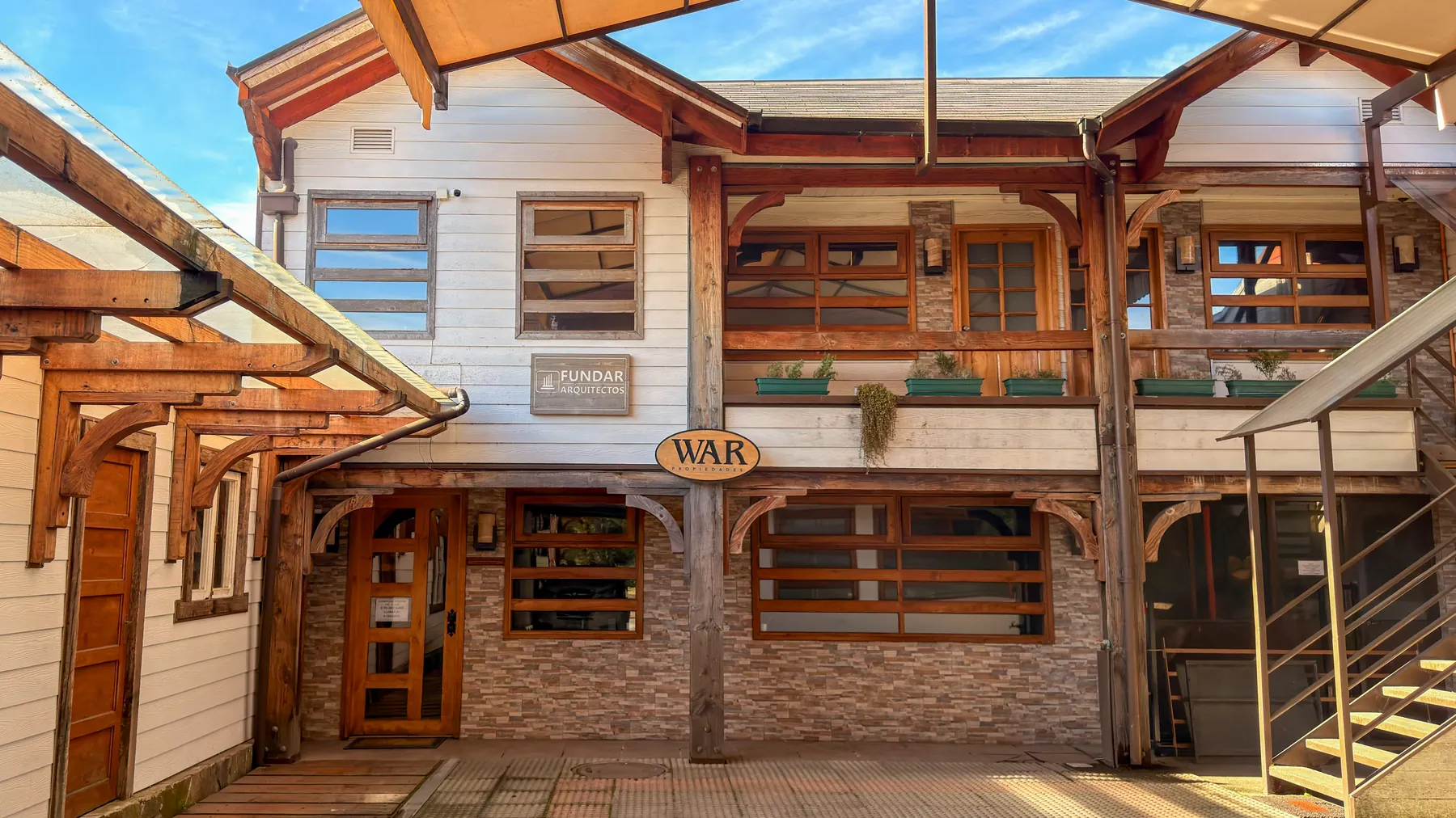 Oficina de WAR Propiedades en Anfión Muñoz 530, Villarrica, con el letrero de la corredora y el de Fundar Arquitectos